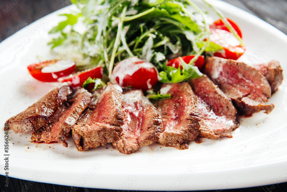 Gourmet roast beef with arugula and tomato salad
