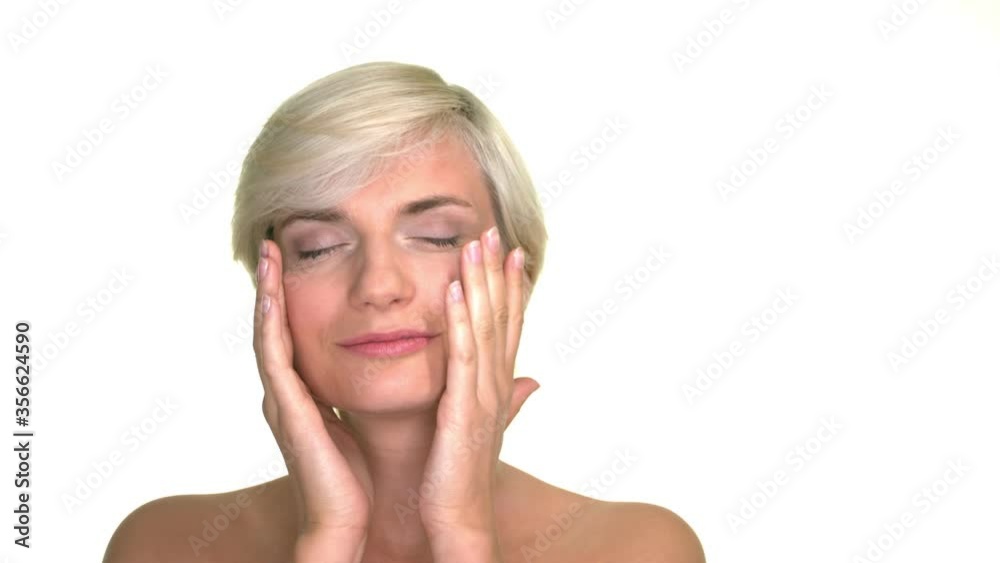 Studio portrait of a beautiful and attractive blond woman gently touching her face. Expressive clip in slow motion. Studio portrait of a beautiful and attractive blond woman gently touching her face. Expressive clip in slow motion.