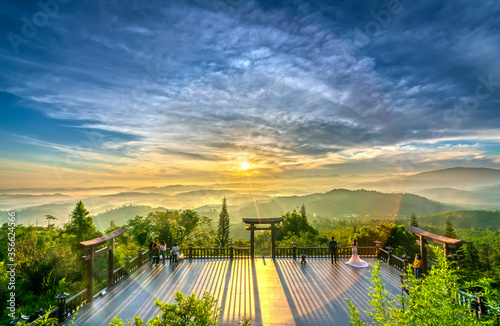 Dawn in front of temple gate with impressive colorful clouds in sky shines under mist valley to attract tourists to relax, meditate near Da Lat , Vietnam