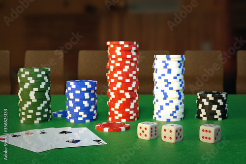 play cards, dices, and casino chips on green table in casino.