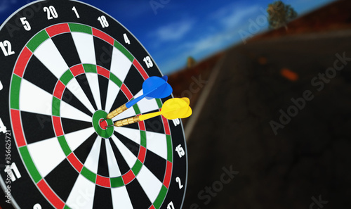 Yellow and blue dart arrow hitting in the Target center of dartboard, concept of the success.