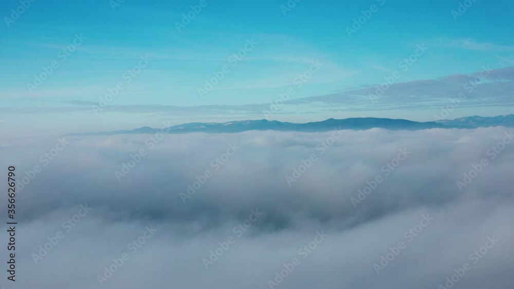 Hills emerge behind blanket of clouds, drone shot. Hills emerge behind blanket of clouds, drone shot.
