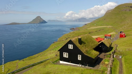 4k drone flight moving to the side footage (Ultra High Definition). summer view of Velbastadur village with typical turf-top houses. Wonderful morning scene of Streymoy island, Faroe, Denmark, Europe.
