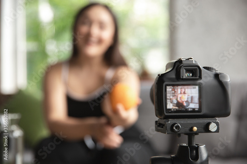 Caucasian blogger, woman make vlog how to diet and lost weight, be body positive, healthy eating. Using camera recording her organic and tasty recipes. Lifestyle influencer, wellness concept.