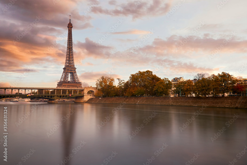 Fototapeta premium The eiffel tower at sunset from the other bank of the seine river and a view on the Bir Hakeim bridge