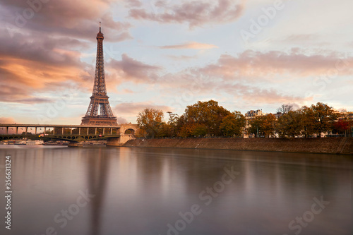 The eiffel tower at sunset from the other bank of the seine river and a view on the Bir Hakeim bridge