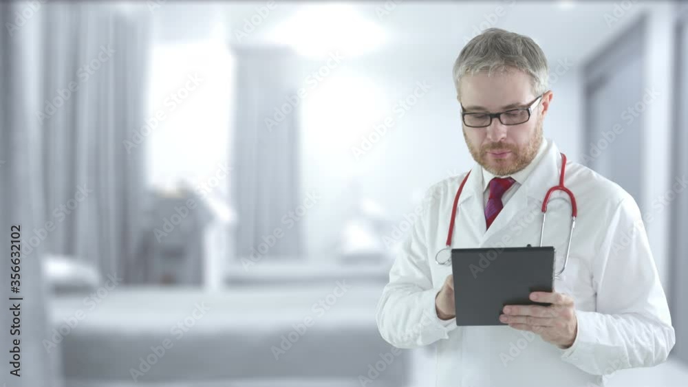 Male doctor uses modern tablet PC in a hospital ward