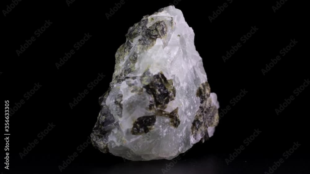 Rock of raw Prehnite mineral slowly rotating over a black background Rock of raw Prehnite mineral slowly rotating over a black background