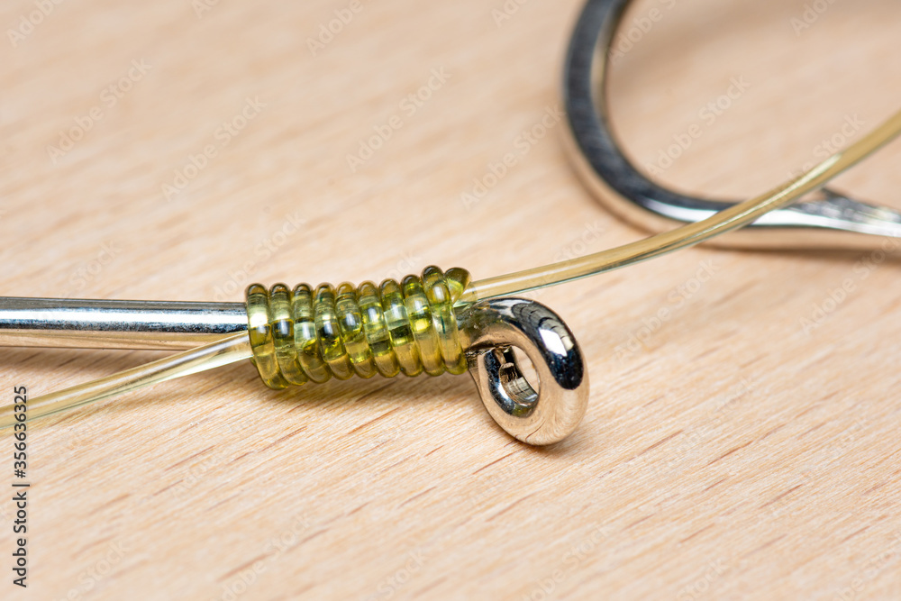 Detail of snell used to join or gang multiple fishing hooks together, snelled linking of hooks. Macro detail, shallow depth of field. Detail of snell used to join or gang multiple fishing hooks together, snelled linking of hooks. Macro detail, shallow depth of field.