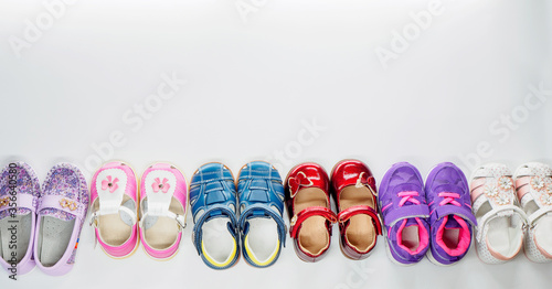 Top view of sandals, moccasins and sneakers at white background with place for text