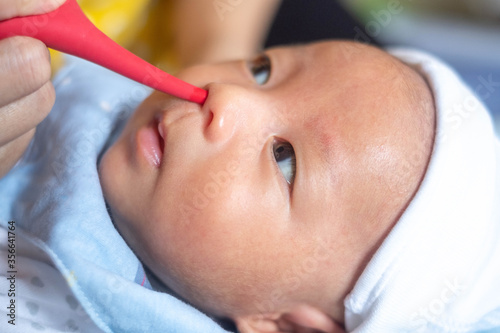 Photography mother using newborn infant baby nasal aspirator mucus nose suction