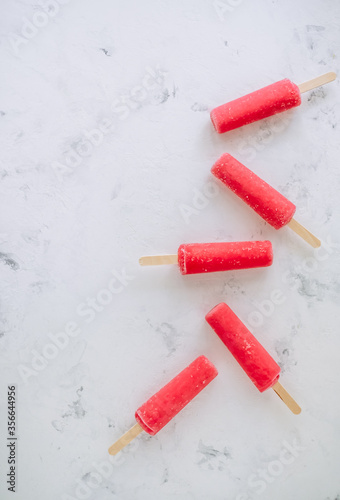 Pink fruit ice sorbet on a white background. Stick ice cream. Flat lay