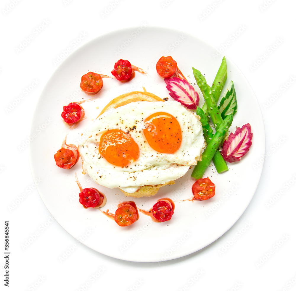 Breakfast with grilled toast on top fried eggs,sprinkle black peppers and salt decorate tomato cherry, asparagus, radish leaf and cucumber carved style top view Breakfast with grilled toast on top fried eggs,sprinkle black peppers and salt decorate tomato cherry, asparagus, radish leaf and cucumber carved style top view