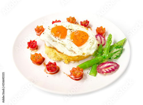 Breakfast with grilled toast on top fried eggs,sprinkle black peppers and salt decorate tomato cherry, asparagus, radish leaf and cucumber carved style side view