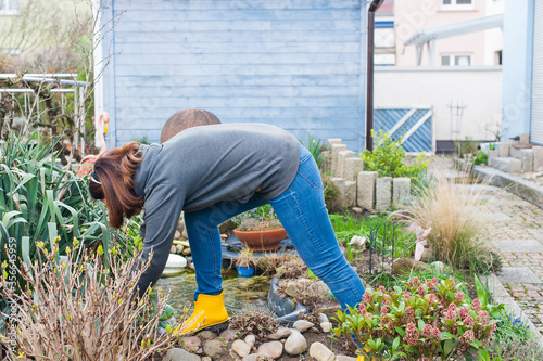 European woman in yellow rubber boots gardening