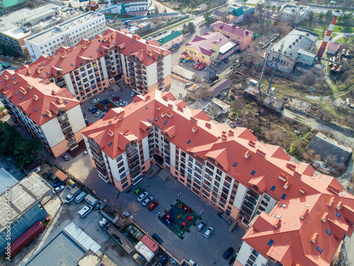 Residential complex of three multi-storey buildings with red roofs. The view from the top.