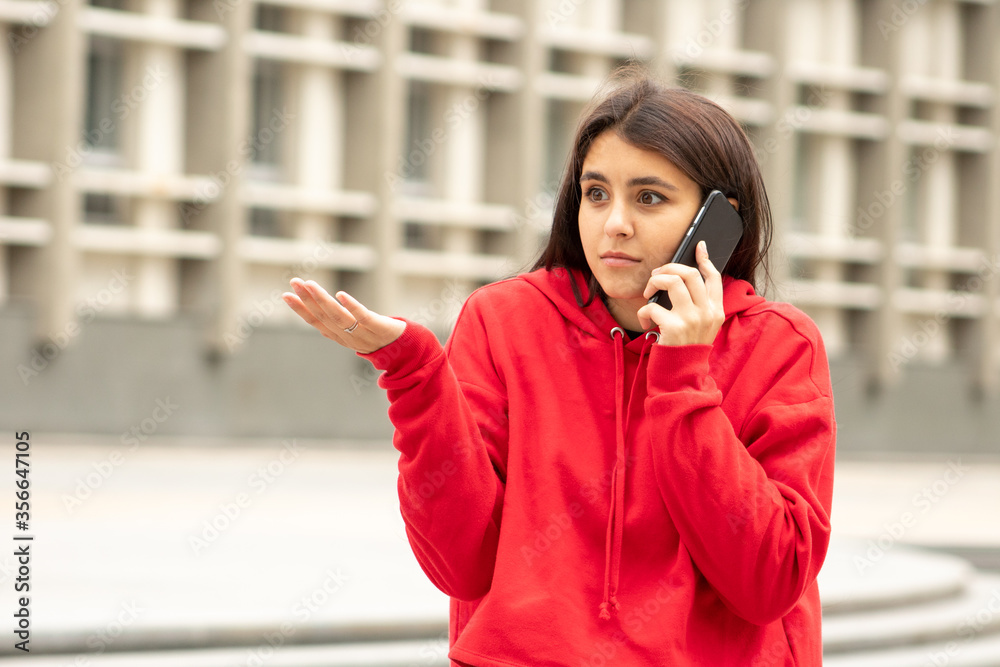 A beautiful woman in red does not know what to answer to the news from her boyfriend A beautiful woman in red does not know what to answer to the news from her boyfriend