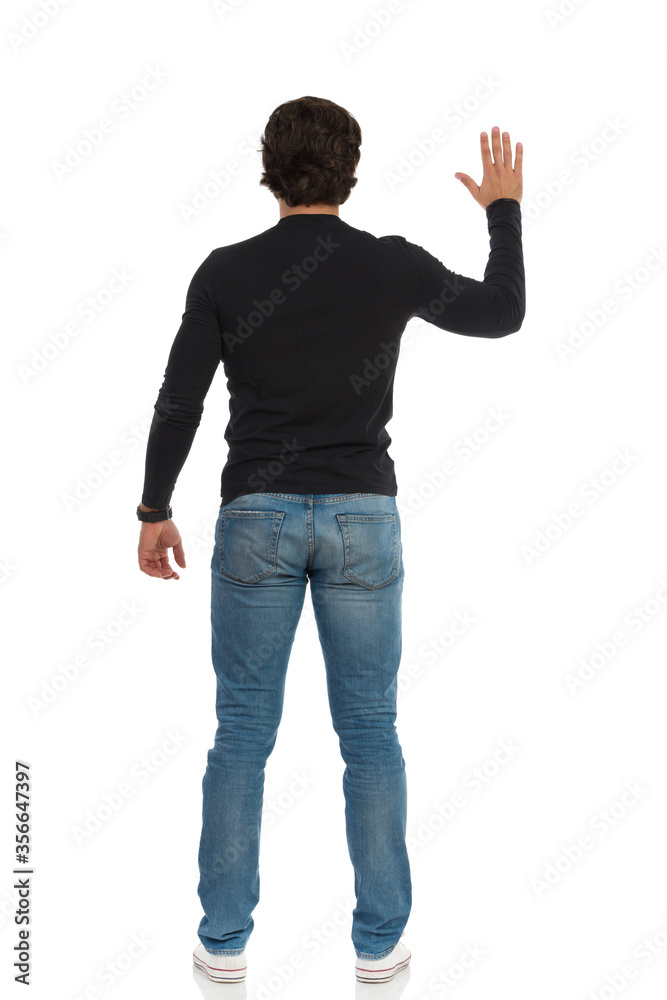 Rear View Of Standing Man With Arm Raised Rear View Of Standing Man With Arm Raised