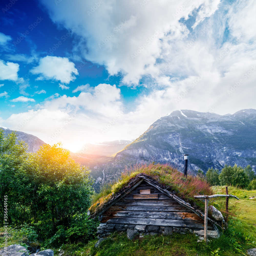 Typical norwegian old wooden houses with grass roofs near Sunnylvsfjorden fjord and famous Seven Sisters waterfalls, western Norway. Landscape photography