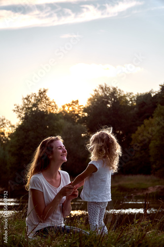 Mom and daughter on the street are looking at each other. Laughter and joy of a woman and a child. High quality photo
