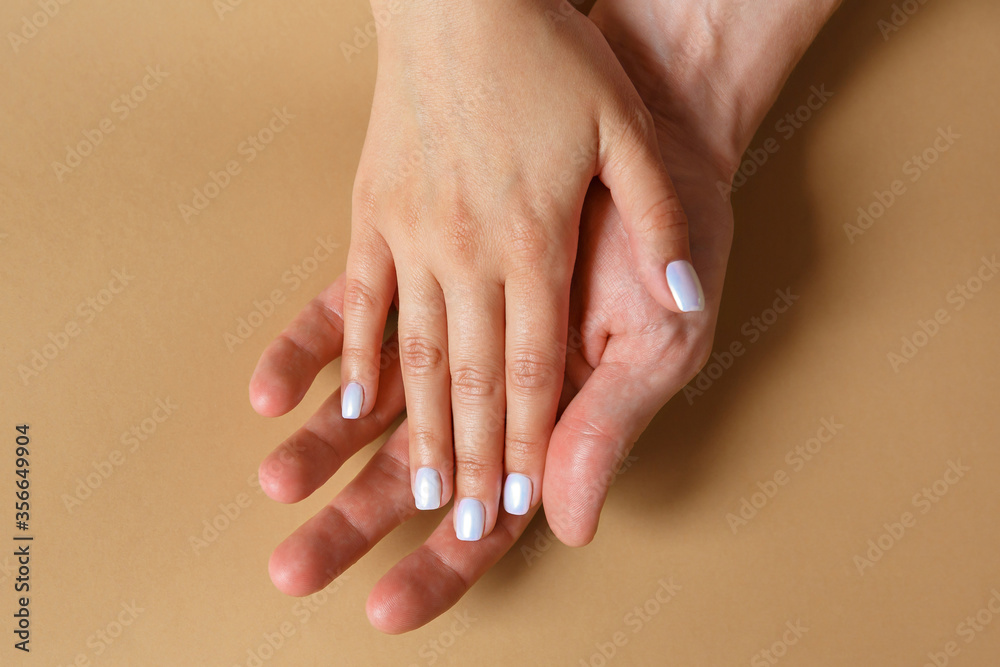 Naklejka premium Male and female hands on a brown background close-up. The concept of love, family and fidelity. Feelings and Attitudes