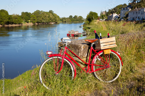 Fotobehang Caisse de bouteilles de vin rouge à l'arrière d'un vieux vélo au bord de la Loire en Anjou, France