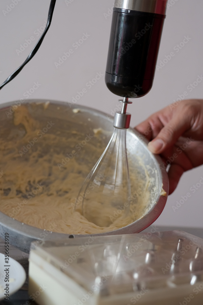 Fototapeta premium Beating cream. Making butter cream filling. Making torte cupcakes with buttercream filling. Motion view.
