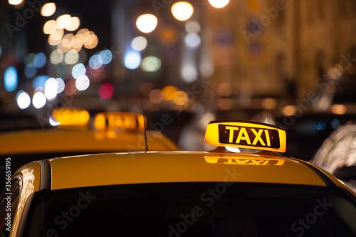 Taxi sign on the roof of a taxi at night