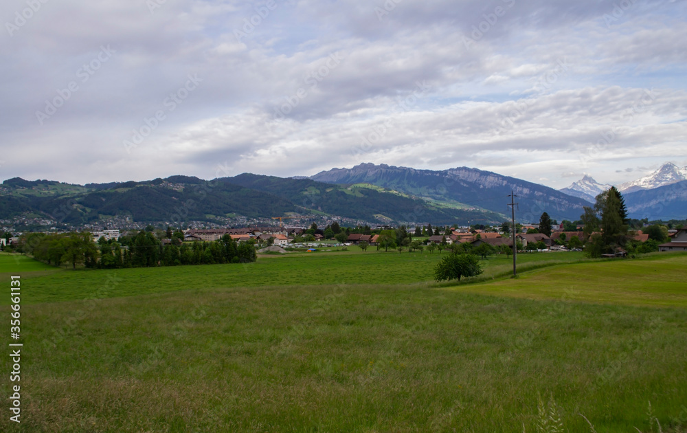 view of alpine mountains and village in Switzerland view of alpine mountains and village in Switzerland