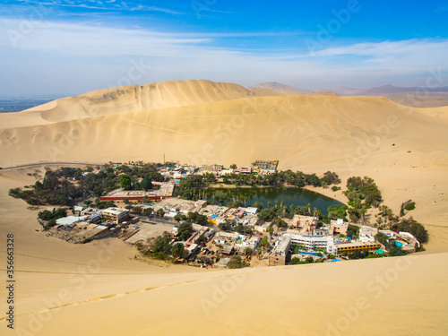 Oasis Huacachina and desert sand dunes of Ica, Peru at a hot, sunny day