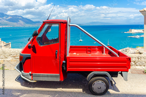 Gaeta, Italy. August 12th 2017. A red Piaggio Ape parked in a scenic road in Gaeta. photo