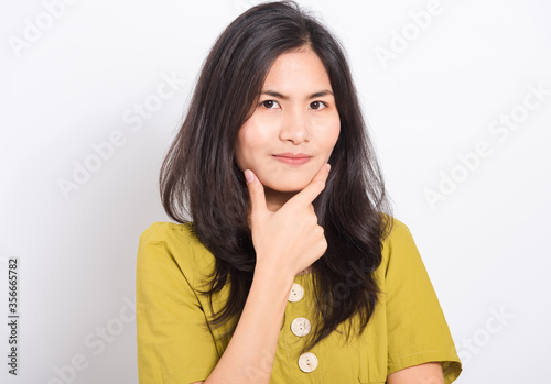Portrait Asian beautiful young woman standing, She thinking or dreaming and looking to camera, shoot photo in studio on white background, There was copy space on the left hand side