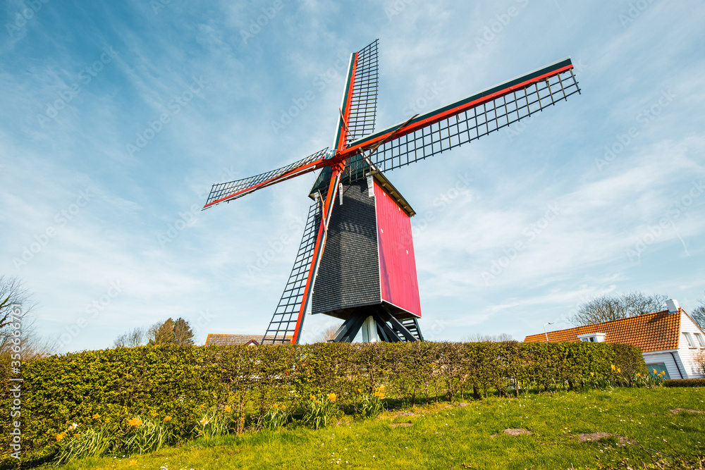 Traditional red wooden windmill against blue sky