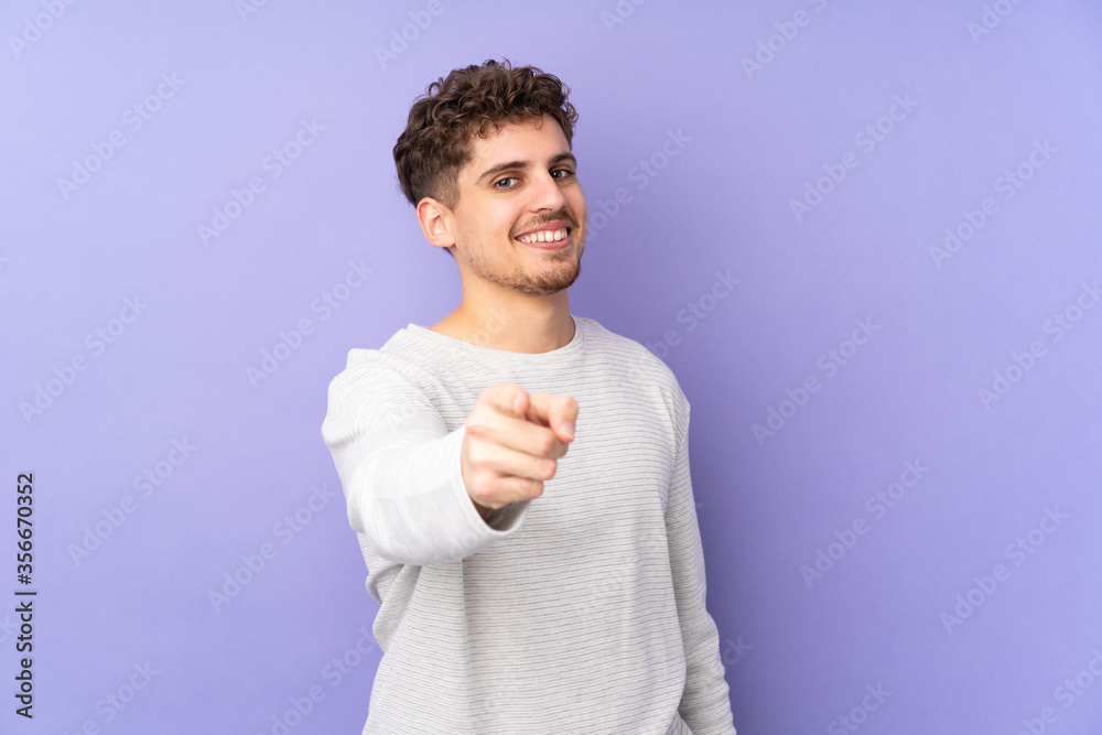 Caucasian man isolated on purple background pointing front with happy expression Caucasian man isolated on purple background pointing front with happy expression
