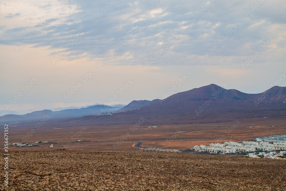  panoramic view of Volcano Montana Roja de Playa Blanca, Lanzarote, Spain. One of the most popular volcano in Canary Islands and the total view of the village in the south with white houses. 
