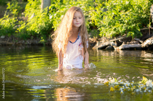 little girl with a wreath in a white dress in the water. Holiday Ivana bathed  © Hanna