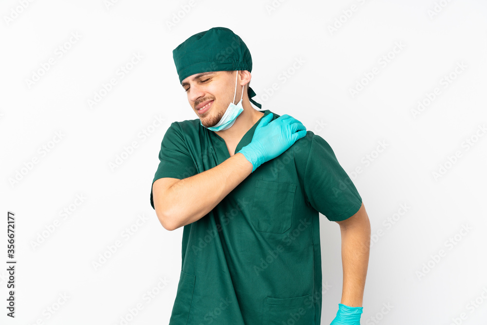 Surgeon in green uniform isolated on isolated white background suffering from pain in shoulder for having made an effort