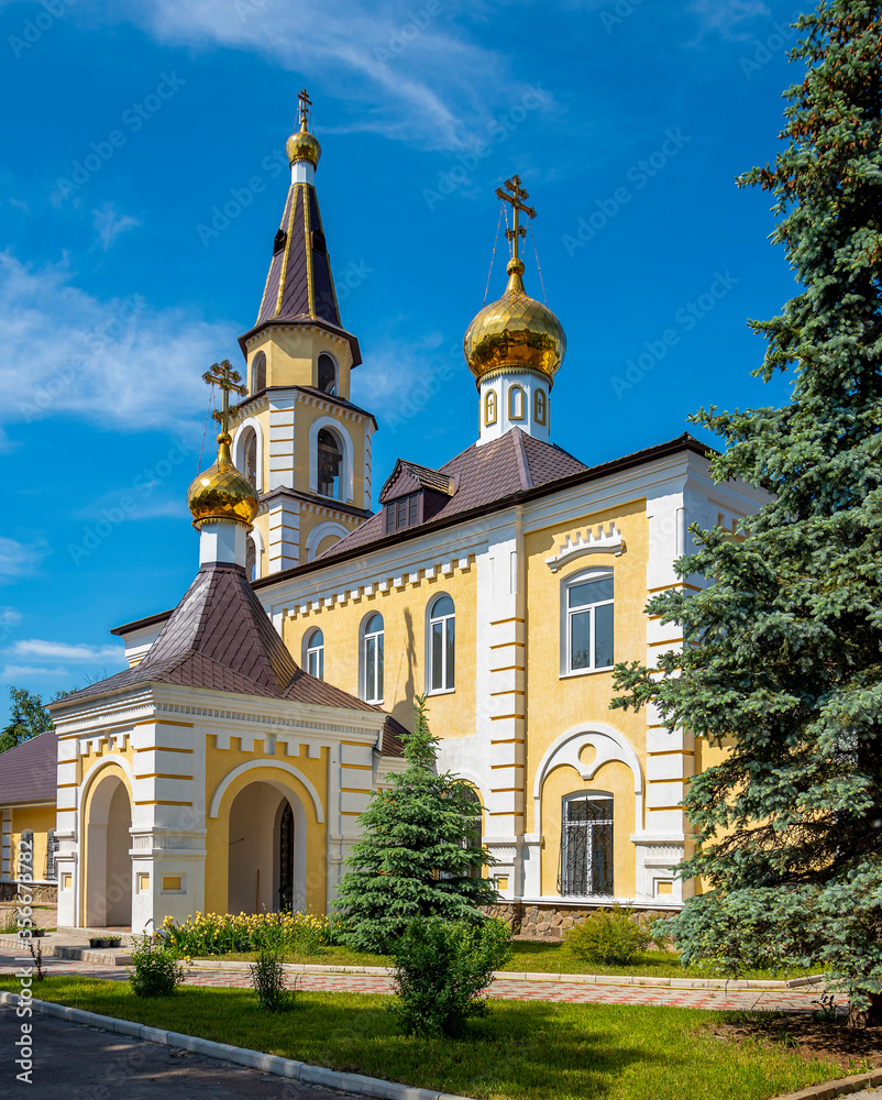 golden-headed Christian church with a bell tower against a blue summer sky