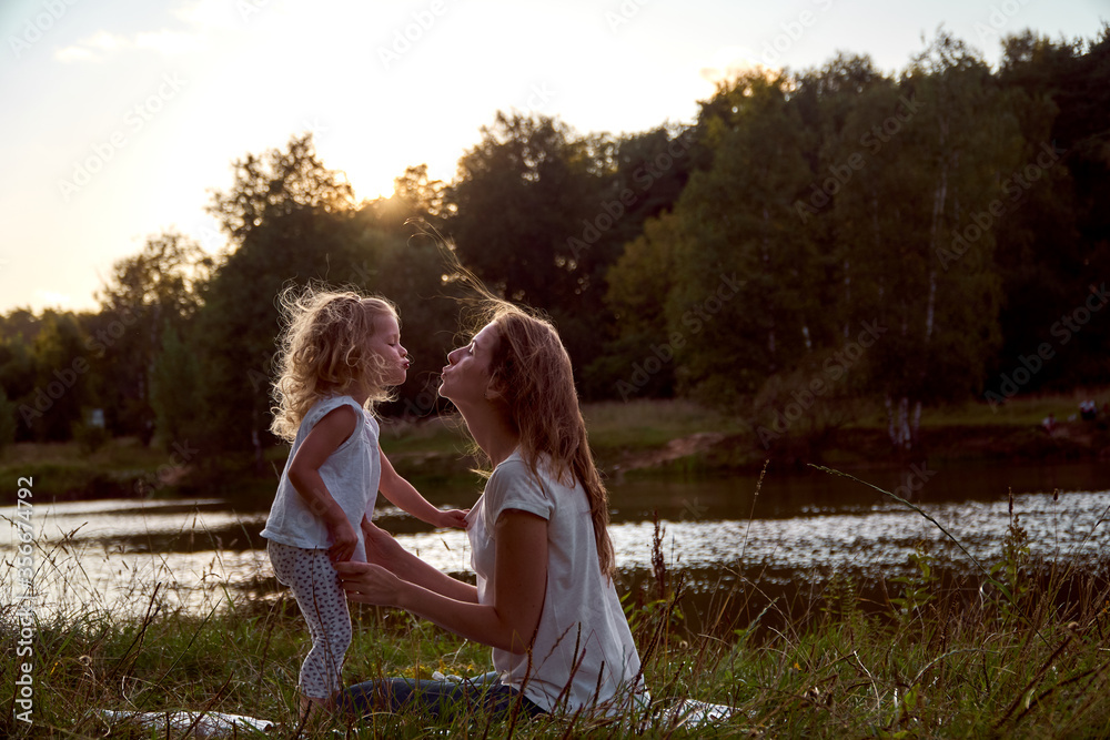 Daughter and mom are hands together. The family is happy. Smiles and laughter. They look at each other. Daughter and mom are hands together. The family is happy. Smiles and laughter. They look at each other.