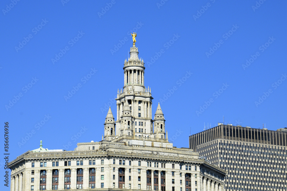 Obraz premium Haute tour à l'architecture ancienne, bâtiment de justice clair, contrastant avec un gratte-ciel style année 70 à manhattan.