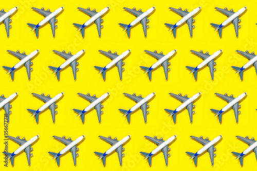 Pattern made of model airplane on yellow background.