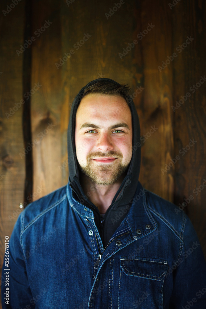 Obraz premium Young man in front of wooden wall
