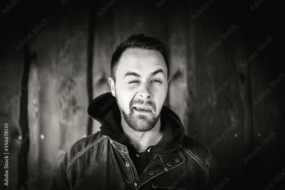 Obraz premium Młody człowiek przed drewnianą ścianą