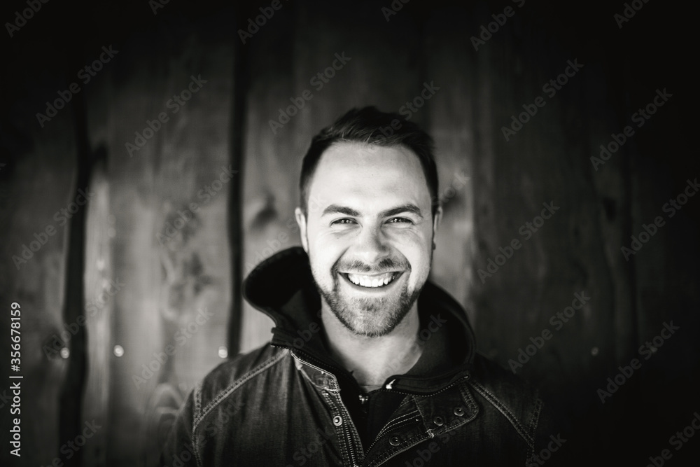 Young man in front of wooden wall Young man in front of wooden wall