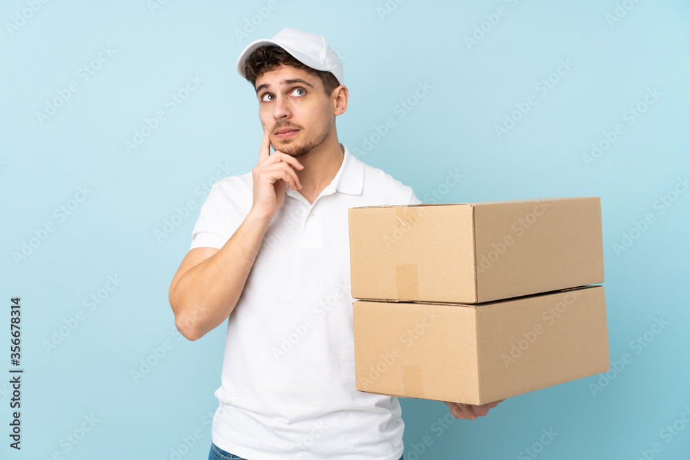 Delivery caucasian man isolated on blue background thinking an idea Delivery caucasian man isolated on blue background thinking an idea