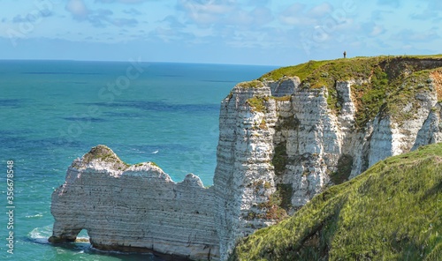 A solitary person looking out to sea on top of the cliffs in Normandy France