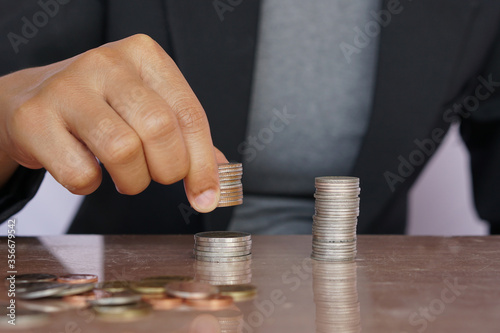 Businesswoman hand putting money coin stack. Creative ideas for saving money concept.