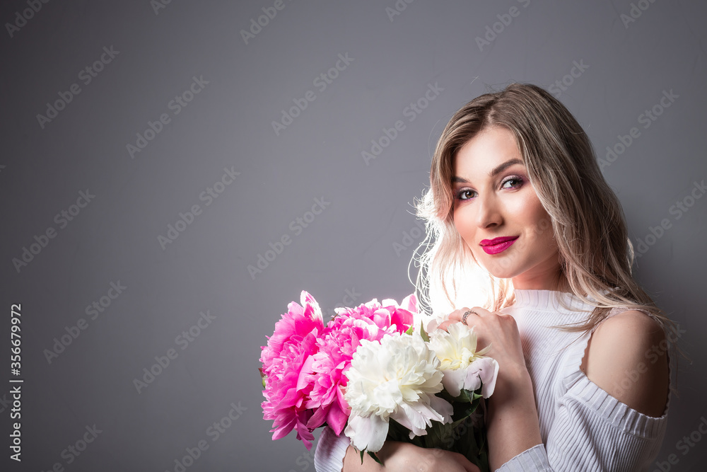 Beautiful young blonde woman with pink flower