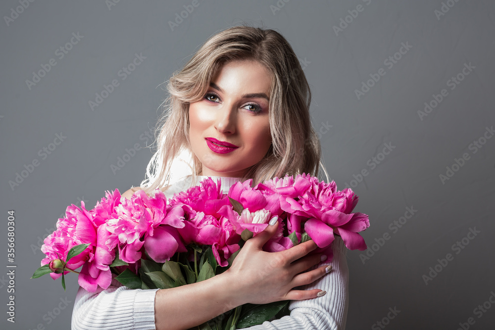 Portrait of a young blonde woman whith pink flowers. Woman's face with make-up and hairstyle Portrait of a young blonde woman whith pink flowers. Woman's face with make-up and hairstyle