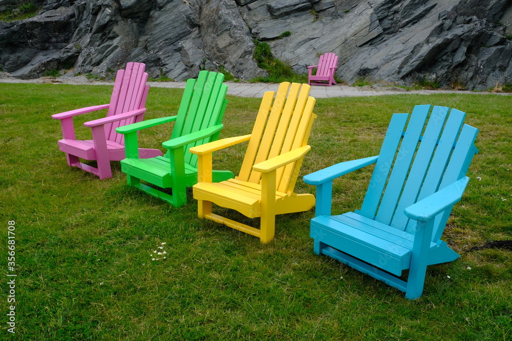 Multicoloured wooden chairs on grass Multicoloured wooden chairs on grass